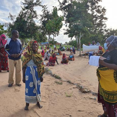 Women leading awareness session before food distribution to flood victims